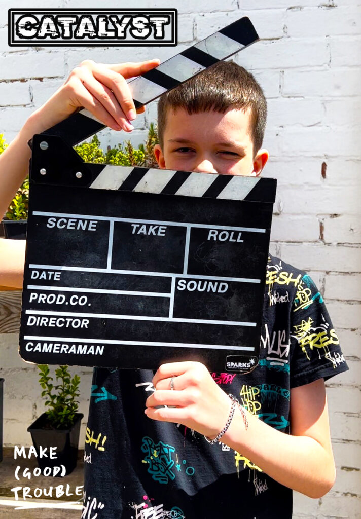 child holding up clapperboard 