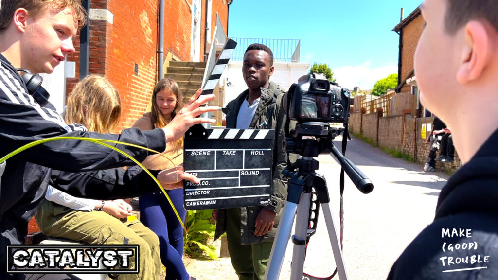 filming team of young people with camera and clapperboard